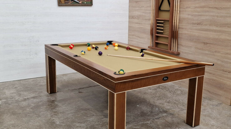 Billard artisanal français qualité : table de billard en bois massif avec queues et billes multicolores dans une salle, ambiance atelier.